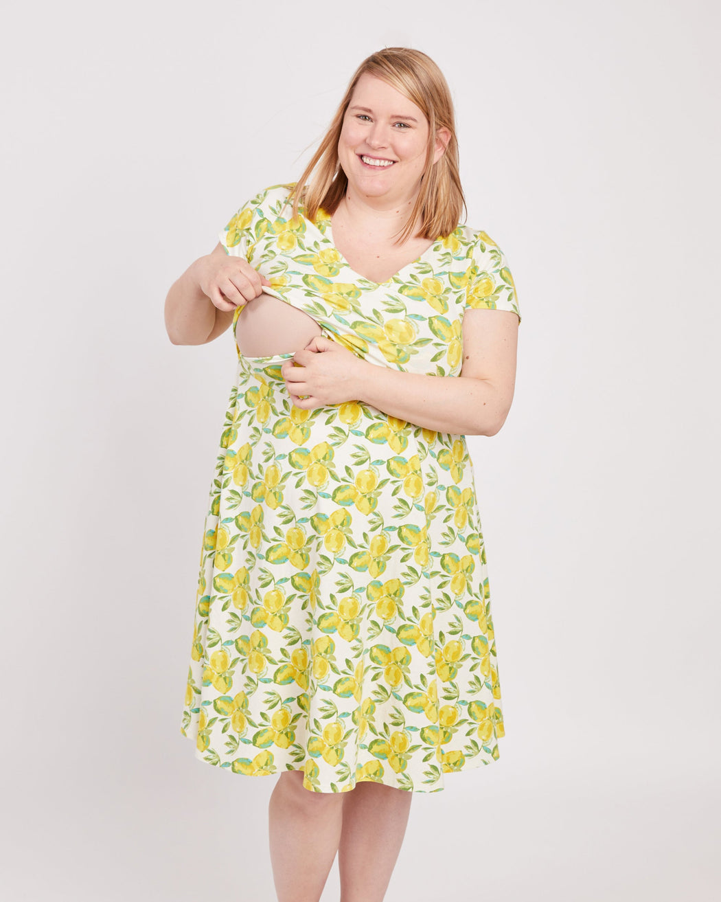 Woman wearing a yellow floral dress on a white background. This is the nursing expansion pack sewing pattern from Cashmerette.