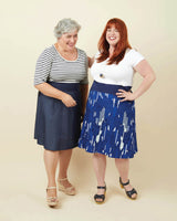 Two women wearing navy skirts with white patterns against a beige background. This dress is the Washington Dress sewing pattern from Cashmerette.