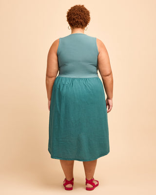 Person wearing a teal dress on a beige background. This is the Duxbury Dress sewing pattern from Cashmerette.