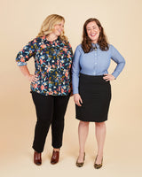 Two women standing side by side against a beige background, wearing colorful shirts and black pants.. This button-up shirt is the Harrison Shirt sewing pattern from Cashmerette.