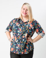 Woman wearing a floral patterned shirt on a white background. This button-up shirt is the Harrison Shirt sewing pattern from Cashmerette.