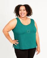 Woman wearing a teal sleeveless top on a white background. This top is the Springfield Top sewing pattern from Cashmerette.