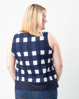 Woman wearing a blue and white checkered sleeveless top on a white background. This top is the Springfield Top sewing pattern from Cashmerette.