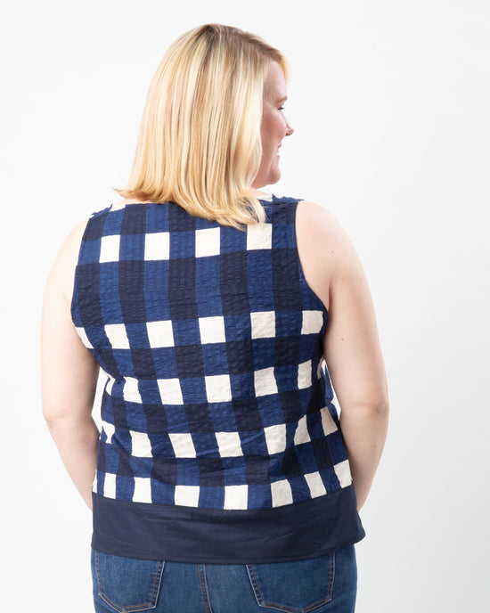 Woman wearing a blue and white checkered sleeveless top on a white background. This top is the Springfield Top sewing pattern from Cashmerette.