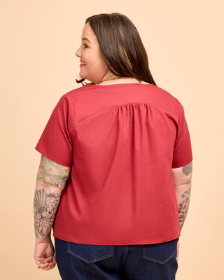 Person wearing a red shirt on a beige background. This is the Montrose Top sewing pattern from Cashmerette.