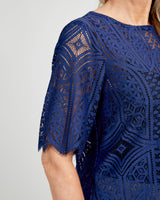 Navy blue lace dress with geometric pattern on a plain background. This top is the Montrose Top sewing pattern from Cashmerette.