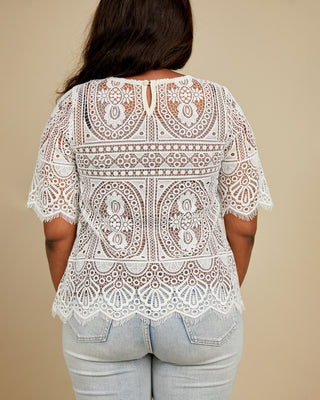 White lace top worn by a person on a beige background. This top is the Montrose Top sewing pattern from Cashmerette.