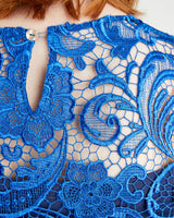 Close-up of blue lace fabric with intricate patterns. This top is the Montrose Top sewing pattern from Cashmerette.