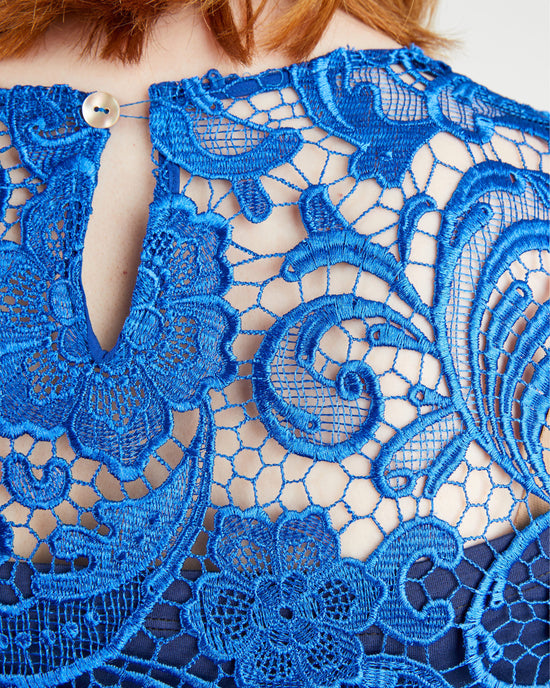 Close-up of blue lace fabric with intricate patterns. This top is the Montrose Top sewing pattern from Cashmerette.