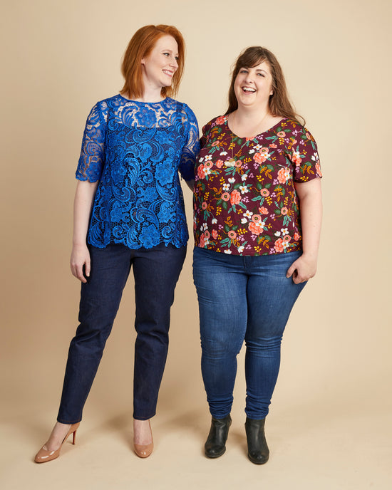 Two women wearing colorful tops and jeans on a beige background. This top is the Montrose Top sewing pattern from Cashmerette.