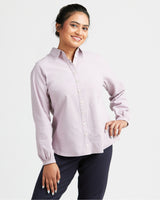 Woman wearing a light purple button-up shirt and dark pants on a white background. This top is the Vernon Shirt sewing pattern from Cashmerette.