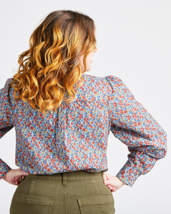 Woman wearing a floral blouse with long sleeves on a plain background. This top is the Vernon Shirt sewing pattern from Cashmerette.