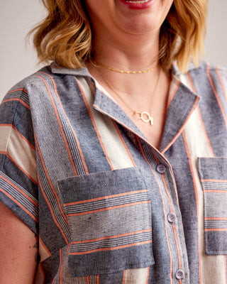 Person wearing a striped shirt with a focus on the collar and chest area.Woman wearing a plaid shirt and denim shorts against a neutral background. This top is the Haskell Shirt sewing pattern from Cashmerette.
