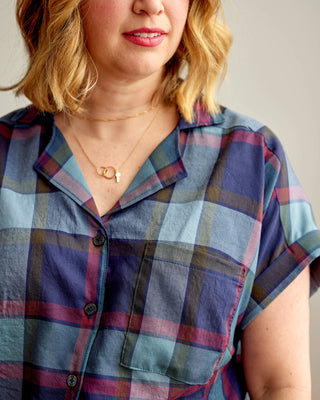Person wearing a plaid shirt with a neutral background. Woman wearing a plaid shirt and denim shorts against a neutral background. This top is the Haskell Shirt sewing pattern from Cashmerette.