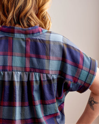 Person wearing a plaid shirt with a neutral background. Woman wearing a plaid shirt and denim shorts against a neutral background. This top is the Haskell Shirt sewing pattern from Cashmerette.