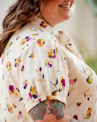 Person wearing a floral blouse with a blurred background. This top is the Swanton Pussy Bow Blouse sewing pattern from Cashmerette.