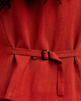 Close-up of a red coat with a belt and black buckle. This vest is the Hartwell Vest sewing pattern from Cashmerette.