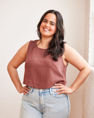 Woman wearing a brown tank top and light blue jeans against a plain background. This top is the Thorndike Tank sewing pattern from Cashmerette.