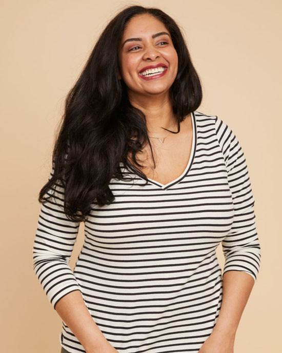 Woman wearing a black and white striped shirt against a beige background. This t-shirt is the Concord T-Shirt sewing pattern from Cashmerette.