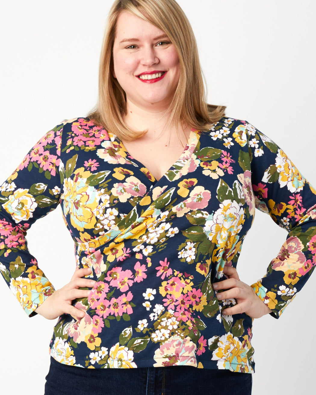 Woman wearing a colorful floral blouse against a white background. This top is the Dartmouth Top sewing pattern from Cashmerette.