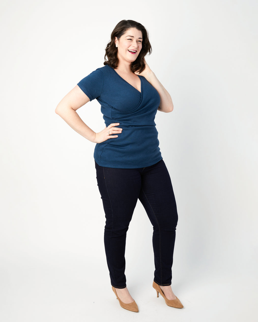 Woman wearing a blue top and black pants on a white background. This top is the Dartmouth Top sewing pattern from Cashmerette.