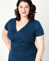 Woman wearing a blue dress against a white background. This top is the Dartmouth Top sewing pattern from Cashmerette.