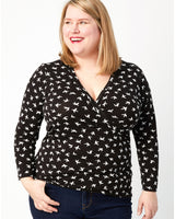 Woman wearing a black long-sleeve shirt with white pattern on a white background. This top is the Dartmouth Top sewing pattern from Cashmerette.