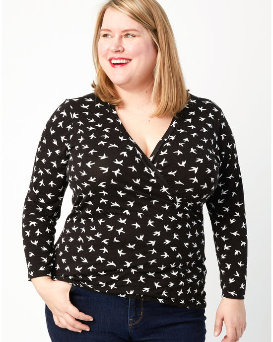 Woman wearing a black long-sleeve shirt with white pattern on a white background. This top is the Dartmouth Top sewing pattern from Cashmerette.