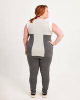 Person wearing a sleeveless top and gray pants on a white background. This top is the Spruce Workout Tank sewing pattern from Cashmerette.
