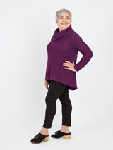 Woman wearing a purple cowl-neck sweater and black pants on a white background. This sweater is the Tobin Sweater sewing pattern from Cashmerette.