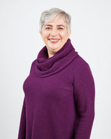 Woman wearing a purple cowl-neck sweater on a white background. This sweater is the Tobin Sweater sewing pattern from Cashmerette.