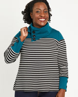 Woman wearing a striped sweater with a teal collar against a plain background. This sweater is the Tobin Sweater sewing pattern from Cashmerette.
