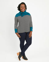 Woman wearing a striped sweater with teal accents on a white background. This sweater is the Tobin Sweater sewing pattern from Cashmerette.