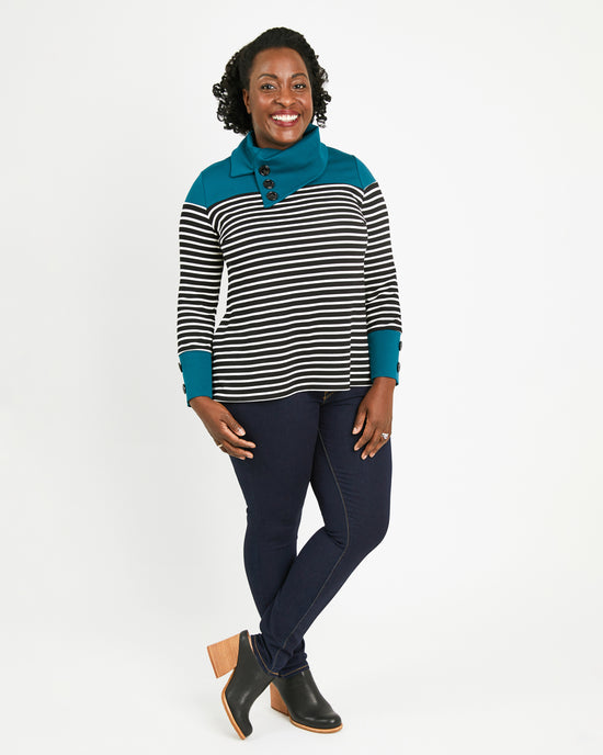 Woman wearing a striped sweater with teal accents on a white background. This sweater is the Tobin Sweater sewing pattern from Cashmerette.