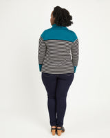 Person wearing a striped shirt with teal accents on a white background. This sweater is the Tobin Sweater sewing pattern from Cashmerette.