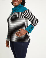 Woman wearing a black and white striped sweater with blue cuffs and collar on a white background. This sweater is the Tobin Sweater sewing pattern from Cashmerette.