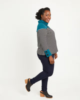 Woman wearing a striped shirt with teal accents on a white background. This sweater is the Tobin Sweater sewing pattern from Cashmerette.
