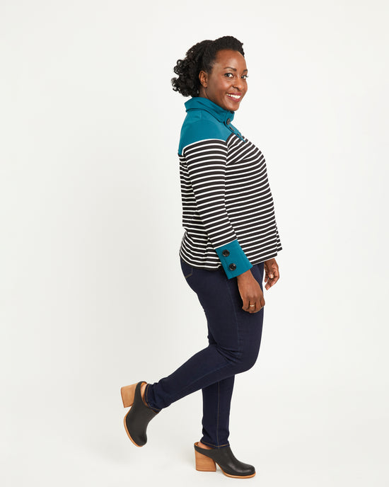 Woman wearing a striped shirt with teal accents on a white background. This sweater is the Tobin Sweater sewing pattern from Cashmerette.