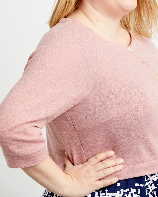 Person wearing a pink sweater with a plain background. This cardigan is the Fuller Cardigan sewing pattern from Cashmerette.