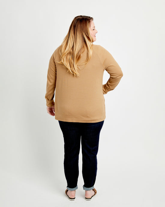 Woman wearing a beige sweater and dark pants on a white background. This cardigan is the Fuller Cardigan sewing pattern from Cashmerette.