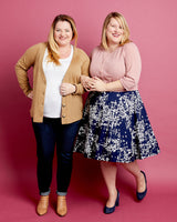 Two women standing side by side against a pink background. This cardigan is the Fuller Cardigan sewing pattern from Cashmerette.