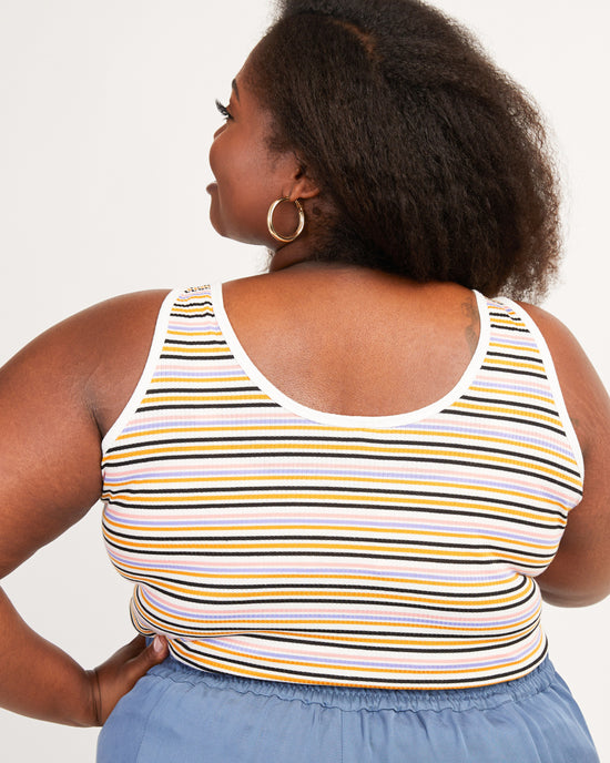Woman wearing a striped tank top with a plain background. This tank top is the Saybrook Tank sewing pattern from Cashmerette.