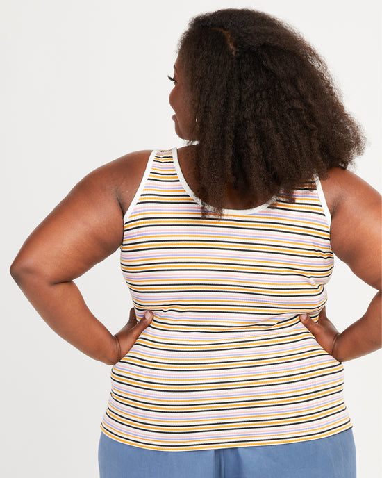 Woman wearing a striped tank top with her hands on her hips against a white background. This tank top is the Saybrook Tank sewing pattern from Cashmerette.