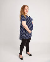 Pregnant woman wearing a blue and white striped dress on a white background. This t-shirt is the Brookline Maternity T-Shirt sewing pattern from Cashmerette.
