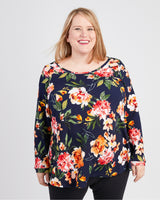 Woman wearing a floral long-sleeve top against a plain background. This t-shirt is the Brookline Maternity T-Shirt sewing pattern from Cashmerette.