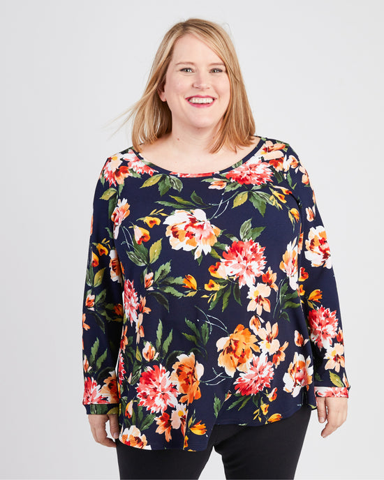 Woman wearing a floral long-sleeve top against a plain background. This t-shirt is the Brookline Maternity T-Shirt sewing pattern from Cashmerette.
