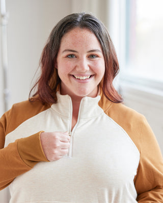 Woman wearing a hoodie with a blurred background. This hoodie is the Stanton Hoodie sewing pattern from Cashmerette.