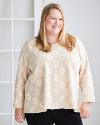 Woman wearing a beige blouse with floral pattern against a white background. This is the Wexford Top & Dress sewing pattern from Cashmerette.