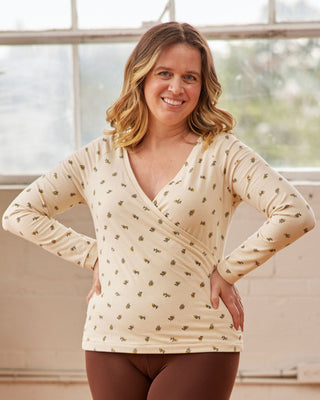 Woman wearing a beige long-sleeve top with a subtle pattern in a bright room. This top is the Kenwin Raglan T-Shirt sewing pattern from Cashmerette.