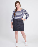 Woman wearing a striped shirt and denim skirt on a white background. This skirt is the Ellis Denim Skirt sewing pattern from Cashmerette.